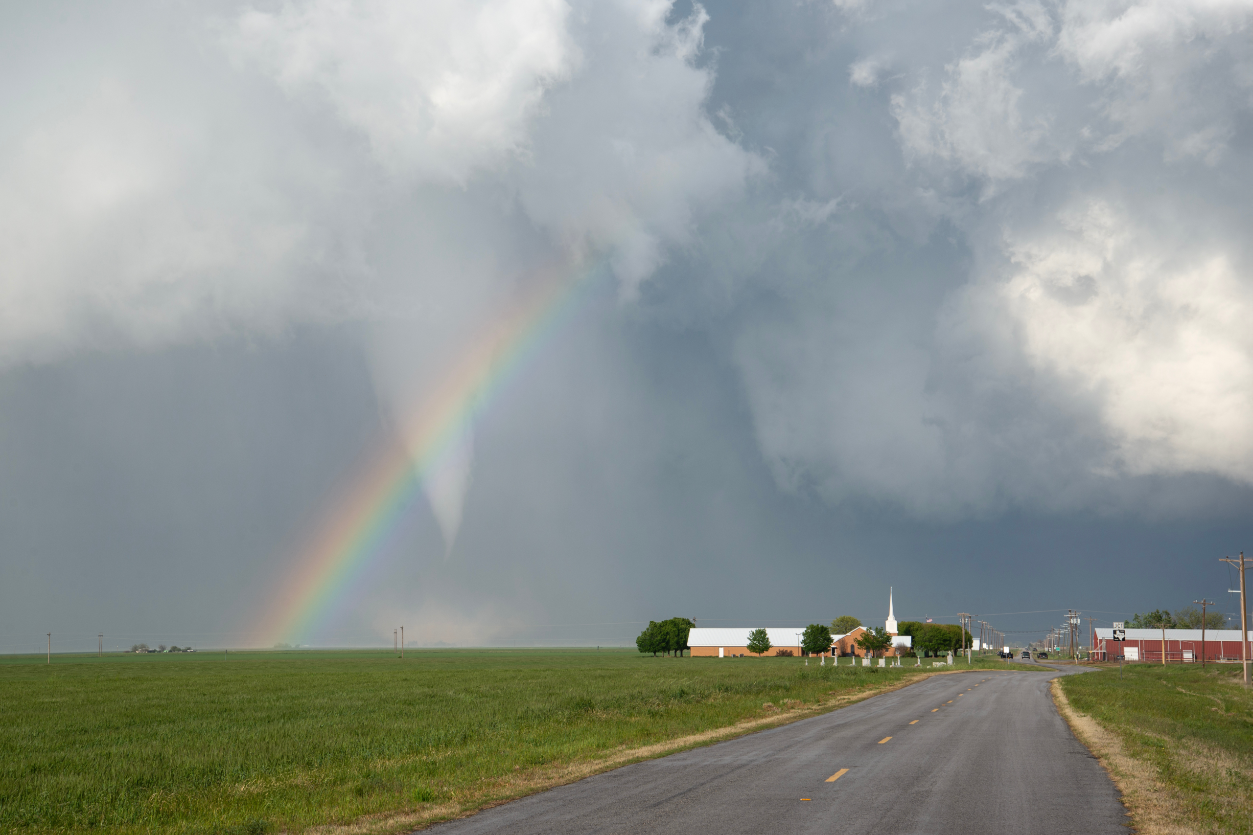 A tornado behind a rainbow and church captured by Jenny in Lockett, TX on 04/23/2021.